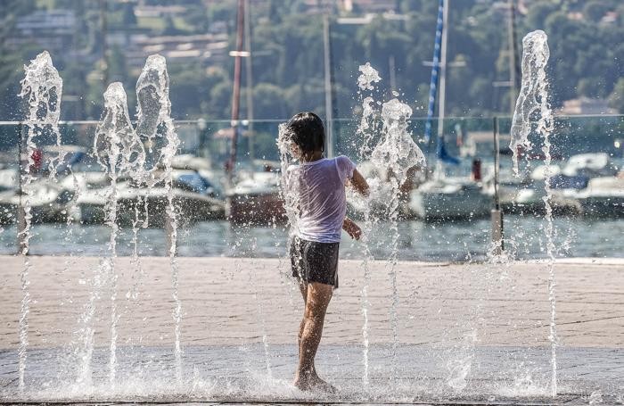 Como caldo record di quest'estate in città , bambini che si rinfrescano alla fontana della passeggiata Amici di Como