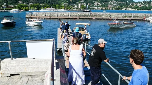 Turisti in attesa e barche in coda al pontile