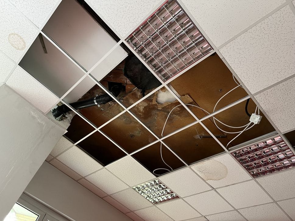 Alcuni dei pannelli del controsoffitto crollati o rimossi a seguito delle infiltrazioni di acqua durante un temporale estivo