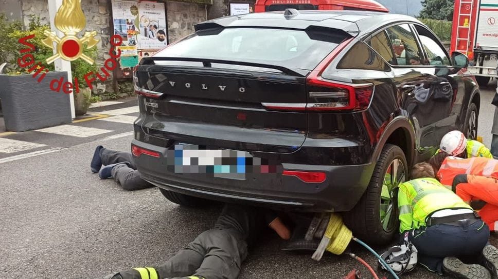 Il bambino incastrato sotto il veicolo mentre i Vigili del fuoco lo stanno liberando