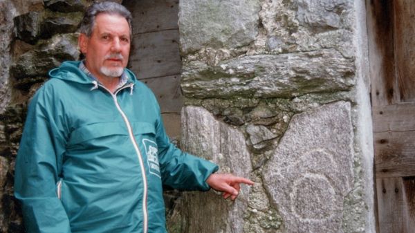 Giovanni Beltramelli accanto a una incisione che aveva scoperto nel territorio lariano