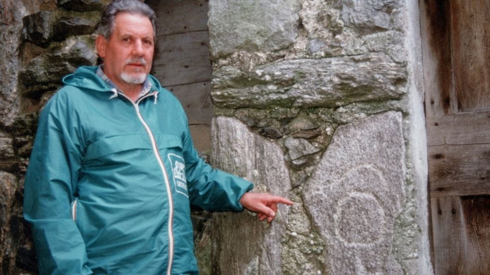 Giovanni Beltramelli accanto a una incisione che aveva scoperto nel territorio lariano