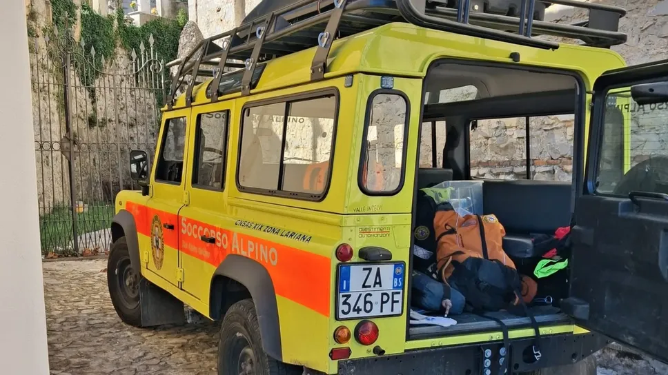 Uno dei mezzi del Soccorso alpino ieri in azione al campo base istituito presso la chiesa di Mezzegra