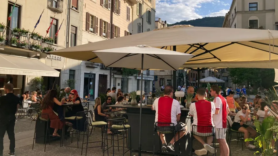 Un gruppo di tifosi con la maglia dell’Ajax ai tavolini di un locale in piazza Volta Un gruppo di tifosi con la maglia dell’Ajax ai tavolini di un locale in piazza Volta
