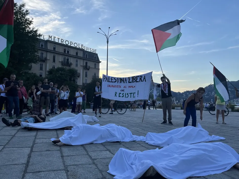 Tra i rumori delle bombe su Gaza, i manifestanti si sono sdraiati a terra e sono stati coperti da lenzuoli bianchi per simulare salme palestinesi