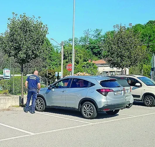 Controlli polizia locale su dischi orari nel parcheggio del supermercato