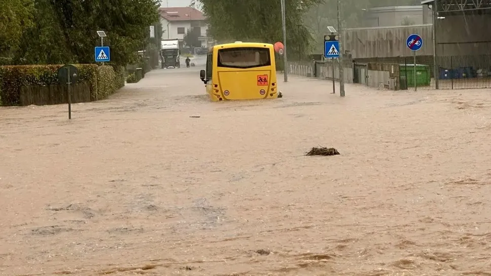 Un bus del trasporto scolastico intrappolato nella strada trasformata in un fiume