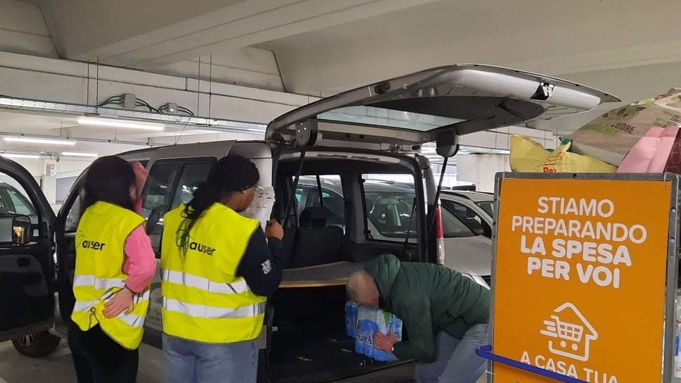 I volontari caricano le borse della spesa a bordo del mezzo associativo