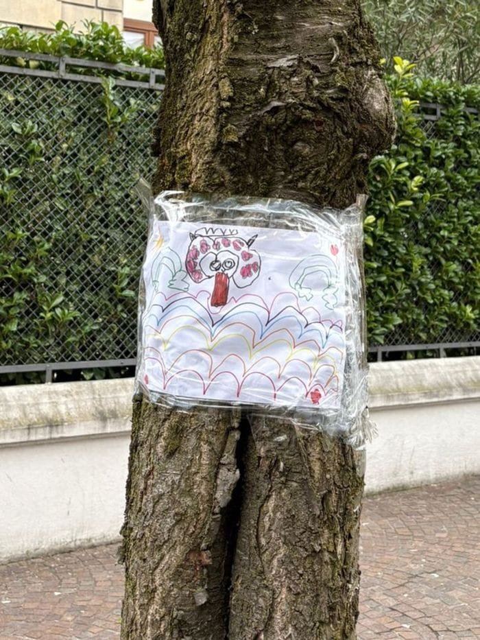 Il cartello con il disegno di un bambino comparso sul tronco di una pianta in via XX Settembre
