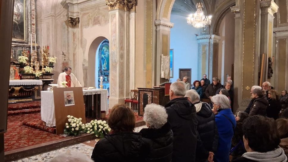 Don Giusto sull’altare della parrocchia di Rebbio con una foto di Severino, nel corso della veglia di ieri