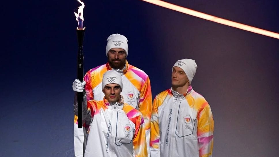 Simone Giannelli con la Fiamma Olimpica, dietro di lui Simone Anzani e Luca Porro