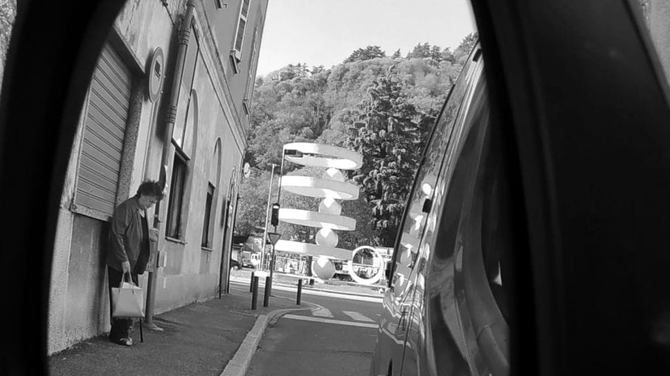 La fontana di Camerlata vista da via Canturina attraverso lo specchietto retrovisore di un’auto