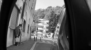 La fontana di Camerlata vista da via Canturina attraverso lo specchietto retrovisore di un’auto